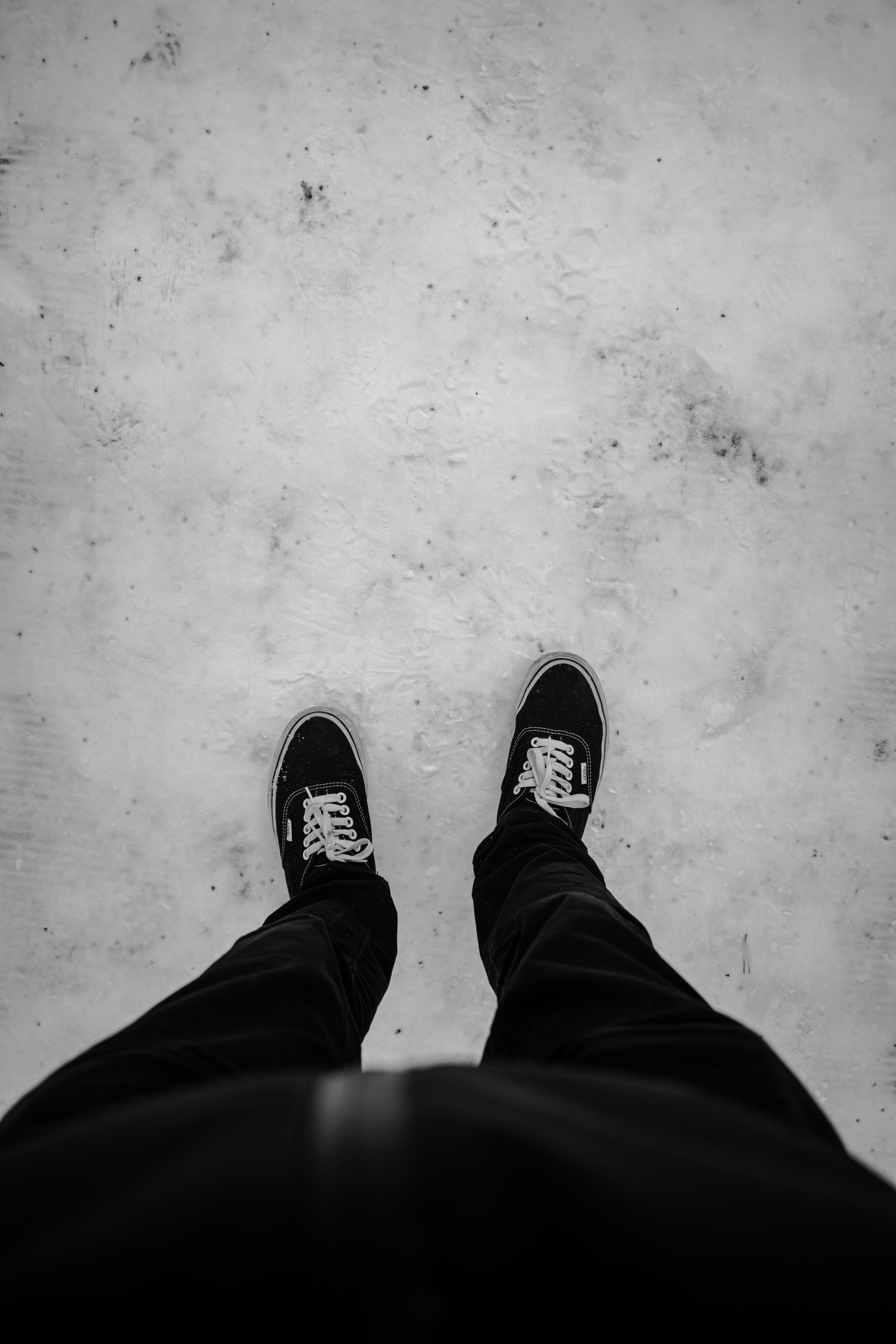 person in black pants and black and white sneakers